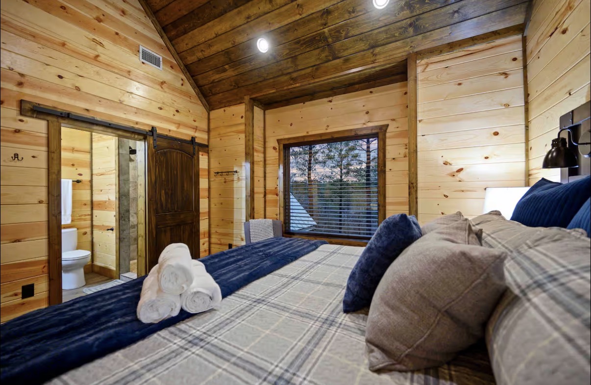 Sound of Sunshine — king bedroom with barn-door en-suite bath and treetop window