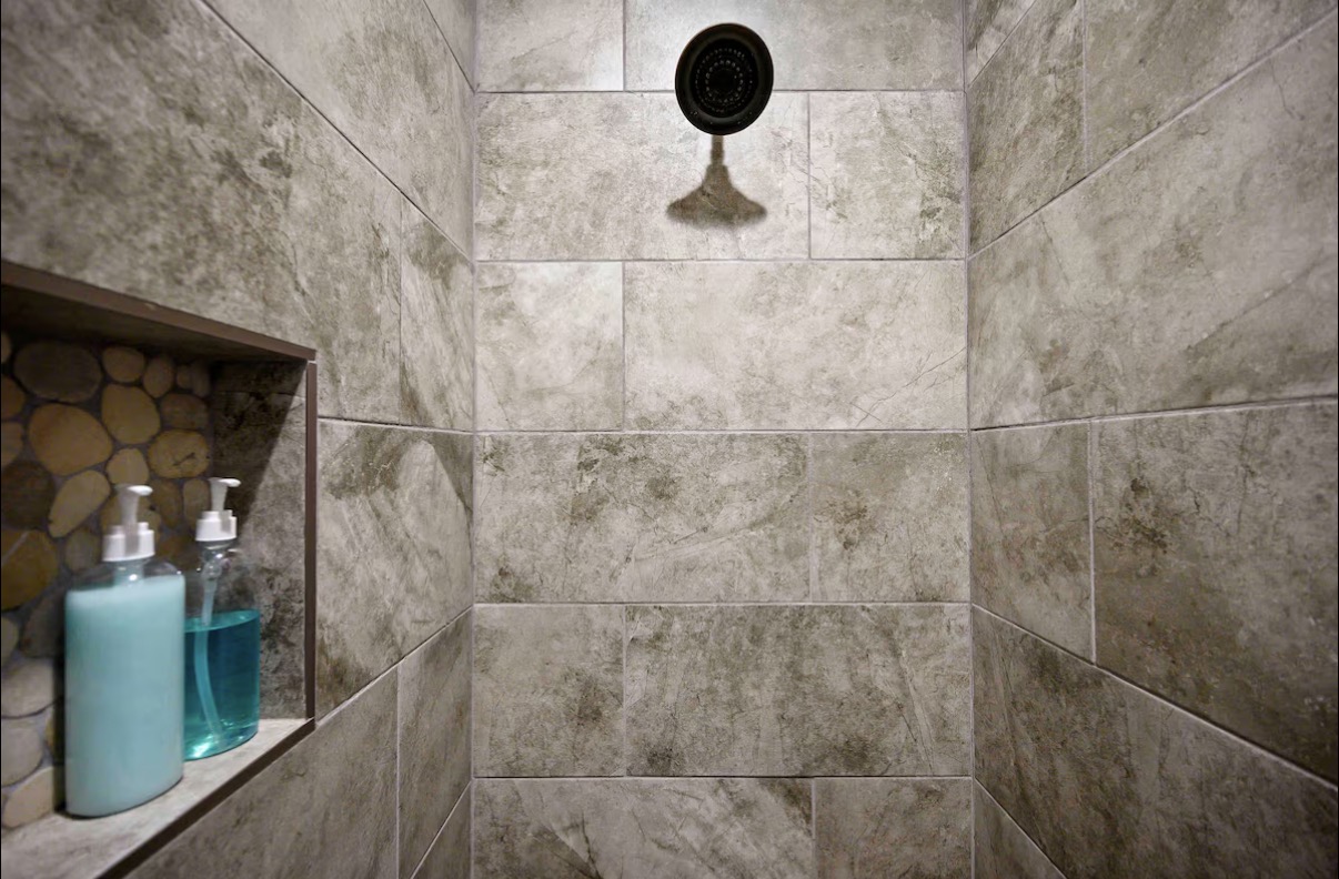 Sound of Sunshine — slate-tile shower with rain head and pebble niche