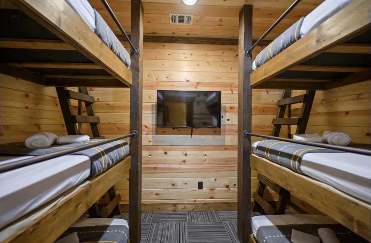 Sound of Sunshine — bunk room with two twin-over-full stacks and mounted TV