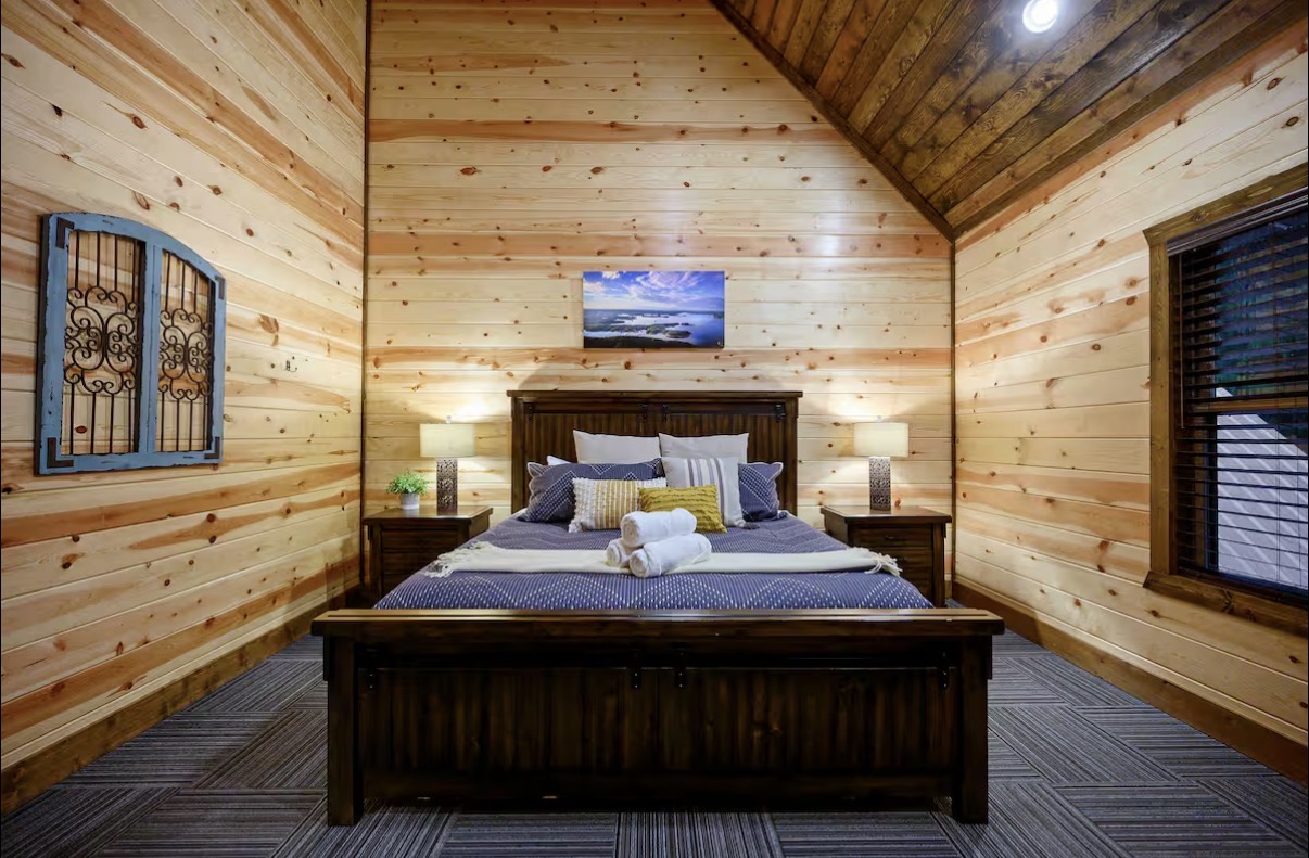 Sound of Sunshine — king bedroom with iron-and-glass wall accent and lake canvas