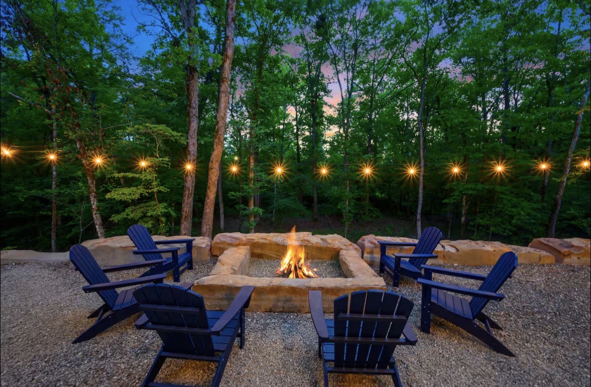 As Good As It Gets — stone fire pit ringed with Adirondack chairs