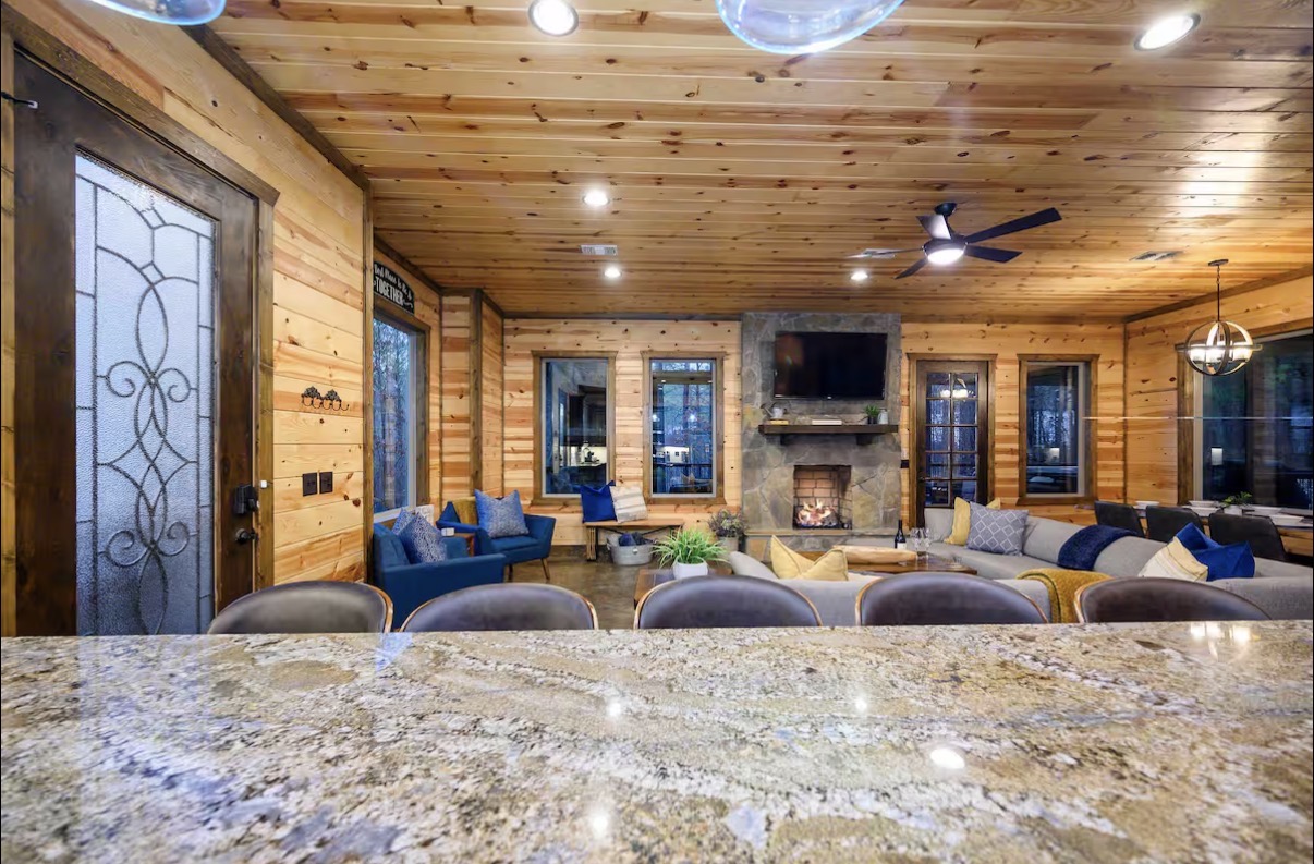 Sound of Sunshine — living room stone fireplace and mounted TV from the island