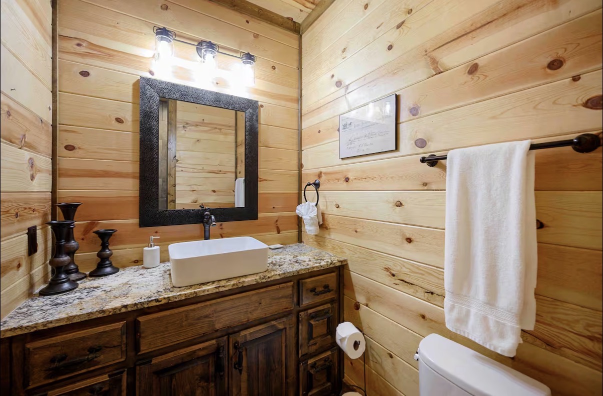 Sound of Sunshine — en-suite powder bath with granite vessel vanity and hammered mirror
