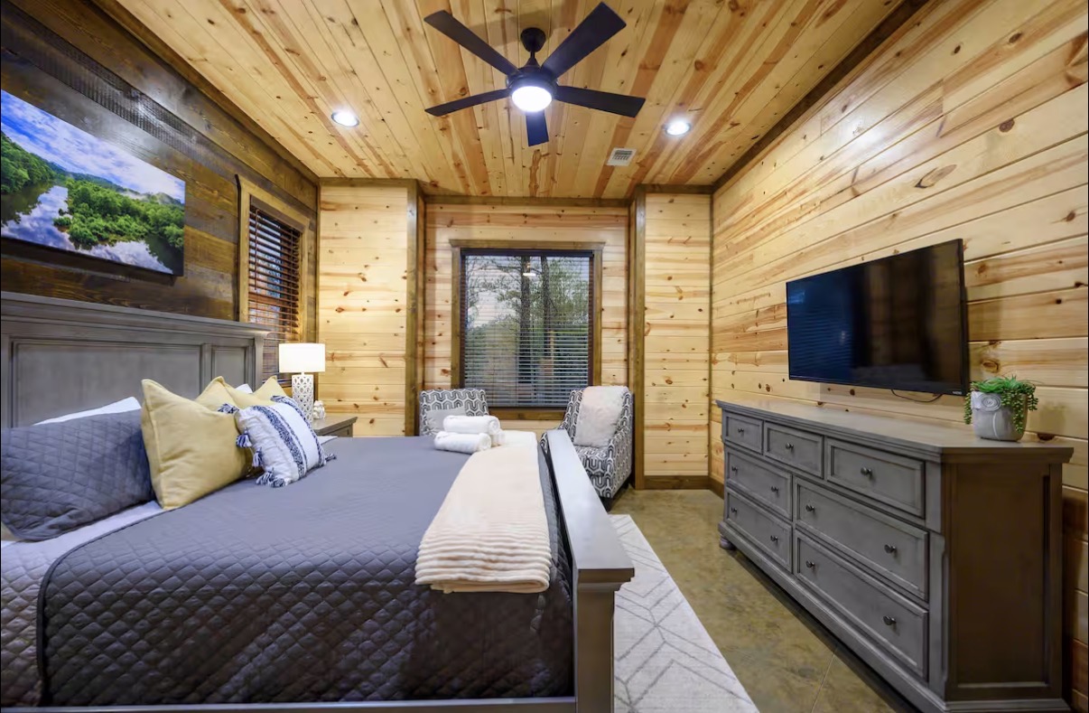 Sound of Sunshine — king bedroom side view with dresser TV and forest window