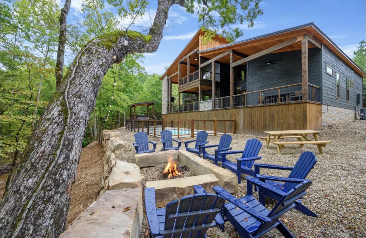 As Good As It Gets — fire pit with Adirondack chairs beside the cabin