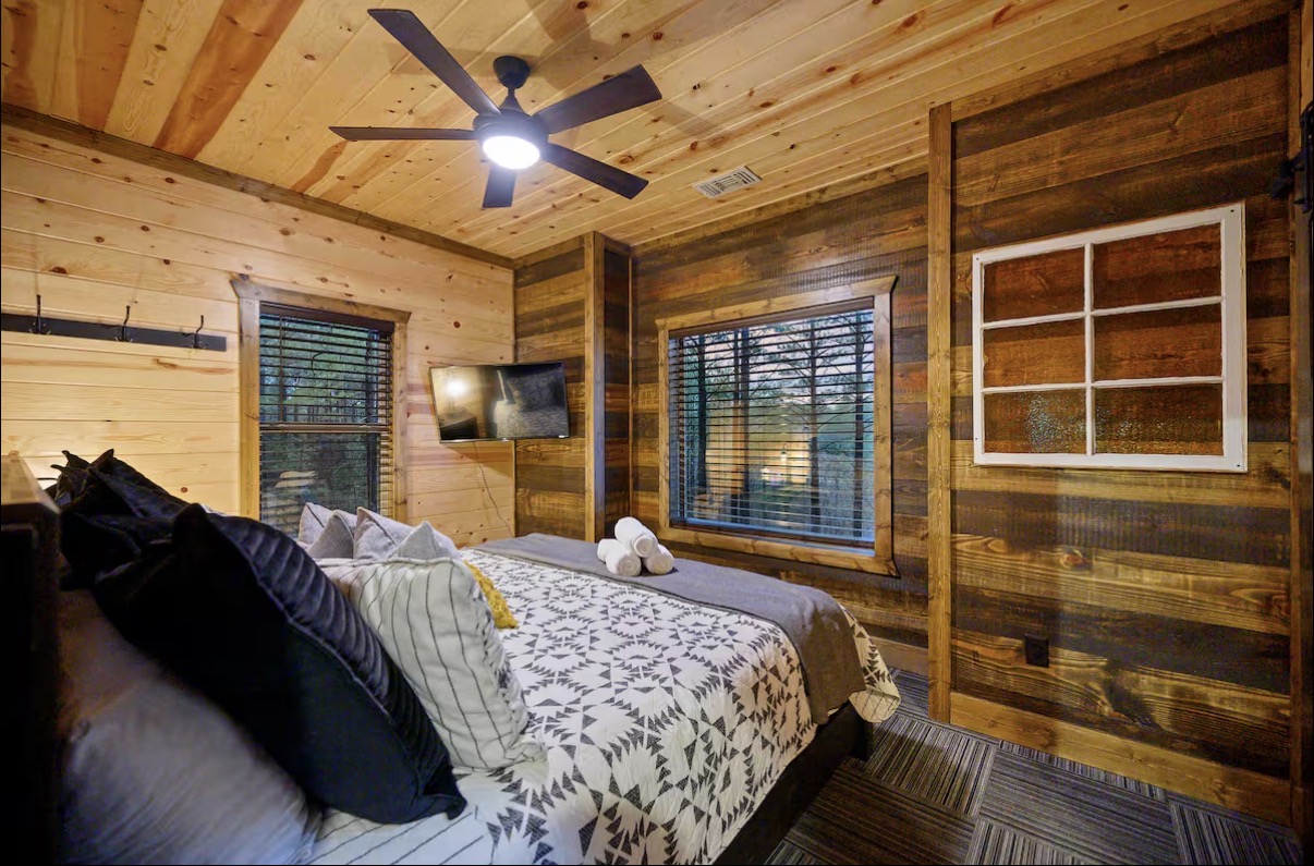 Sound of Sunshine — king bedroom with reclaimed-wood accent wall and mounted TV