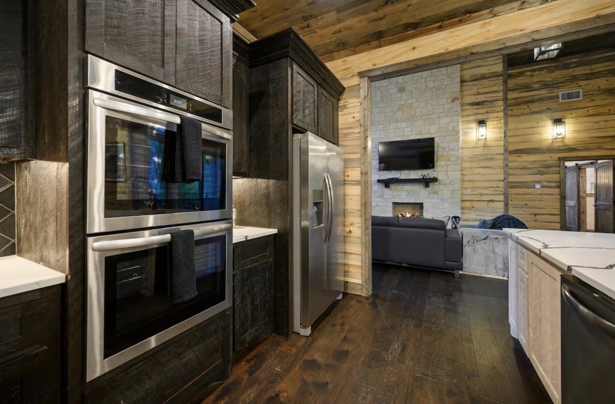 As Good As It Gets — chef's kitchen with double ovens open to the living room