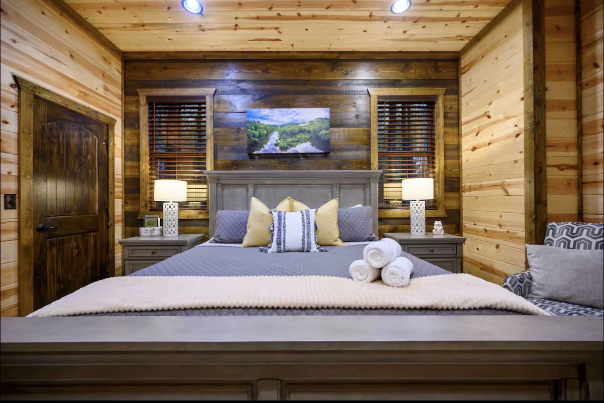 Sound of Sunshine — king bedroom with shiplap accent wall and mounted TV