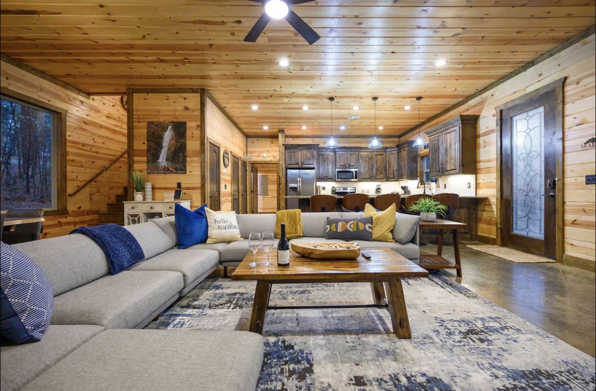Sound of Sunshine — living area toward kitchen with waterfall art and 'hello sunshine' pillow