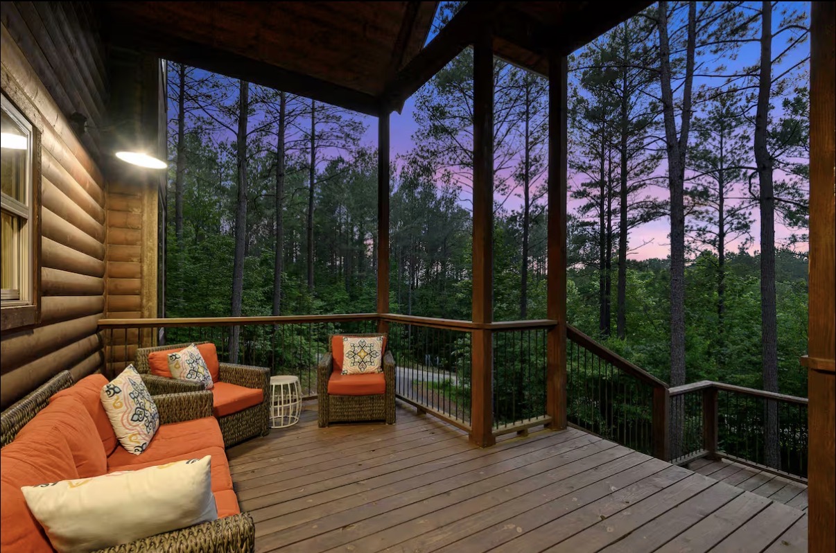 Sound of Sunshine — covered side deck with wicker lounge seating at sunset