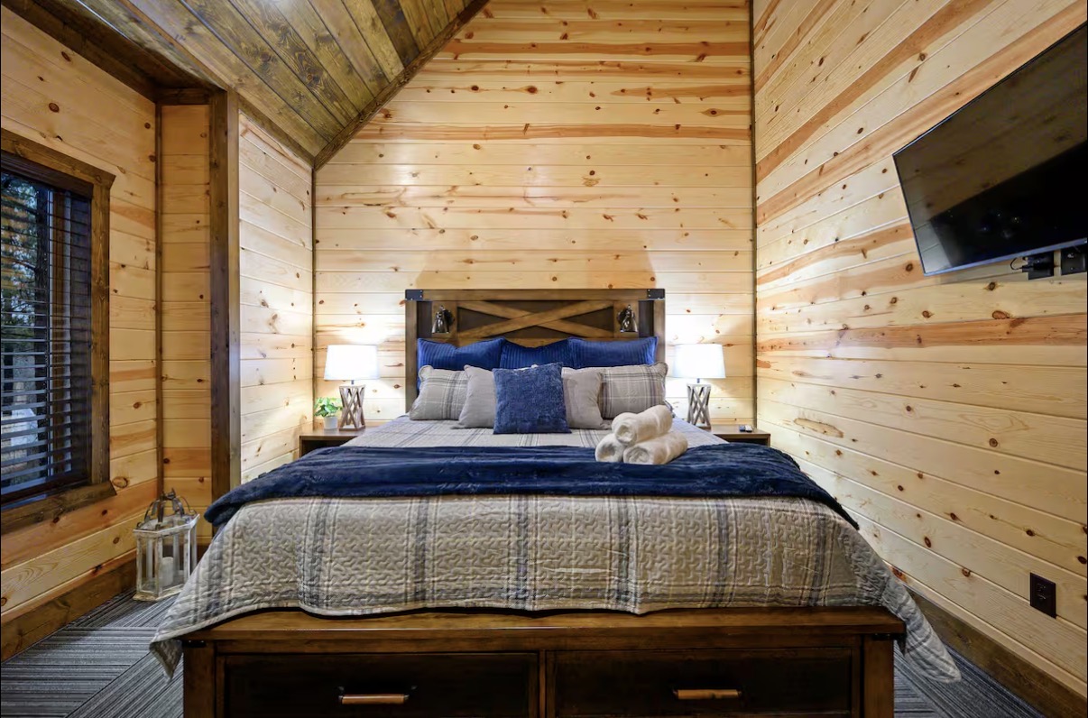 Sound of Sunshine — king bedroom head-on with mounted TV and lantern accent