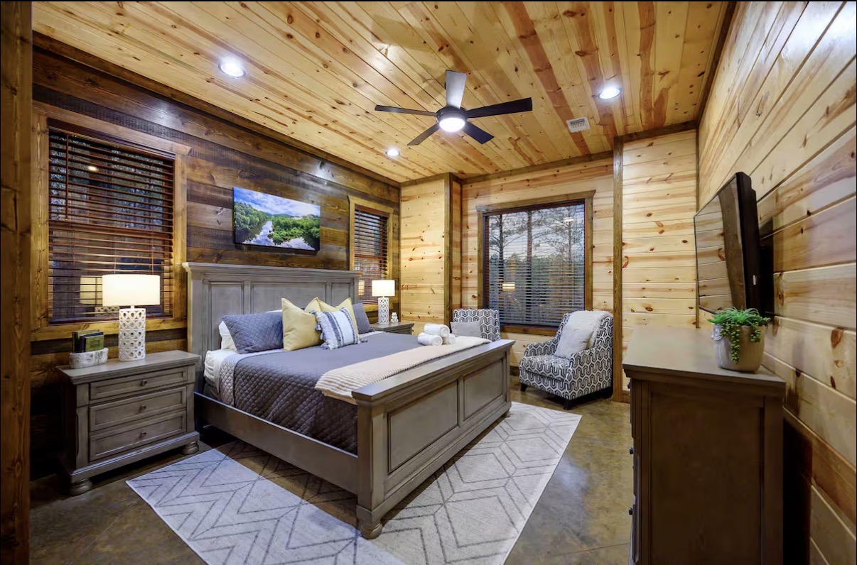 Sound of Sunshine — king bedroom with reading chair and dual TVs