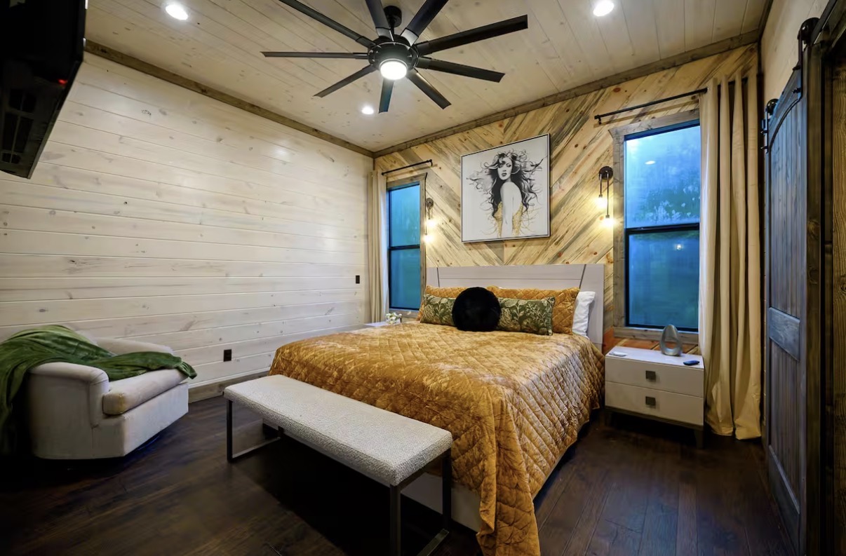 As Good As It Gets — queen bedroom with mounted TV and reading chair